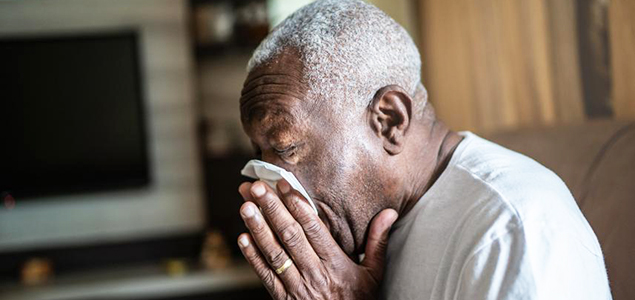 Man blowing nose into tissue